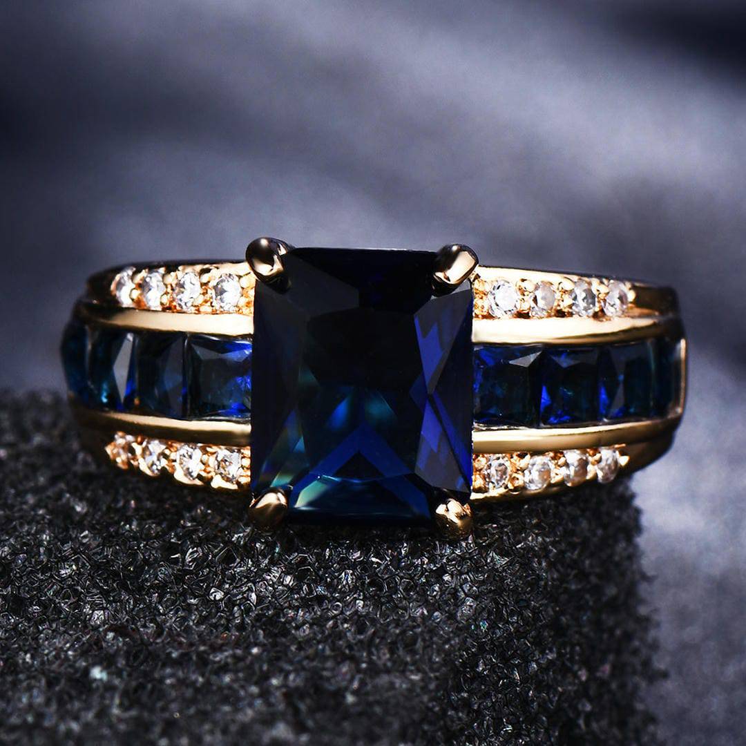 Bague en or avec pierre centrale bleue rectangulaire et pavé de pierres claires
