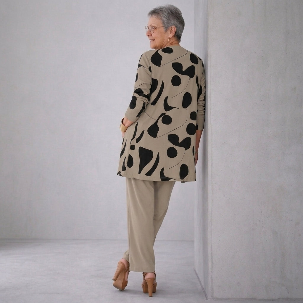Ensemble 3 pièces : veste longue à motifs noirs, coupe droite, haut et pantalon beige.