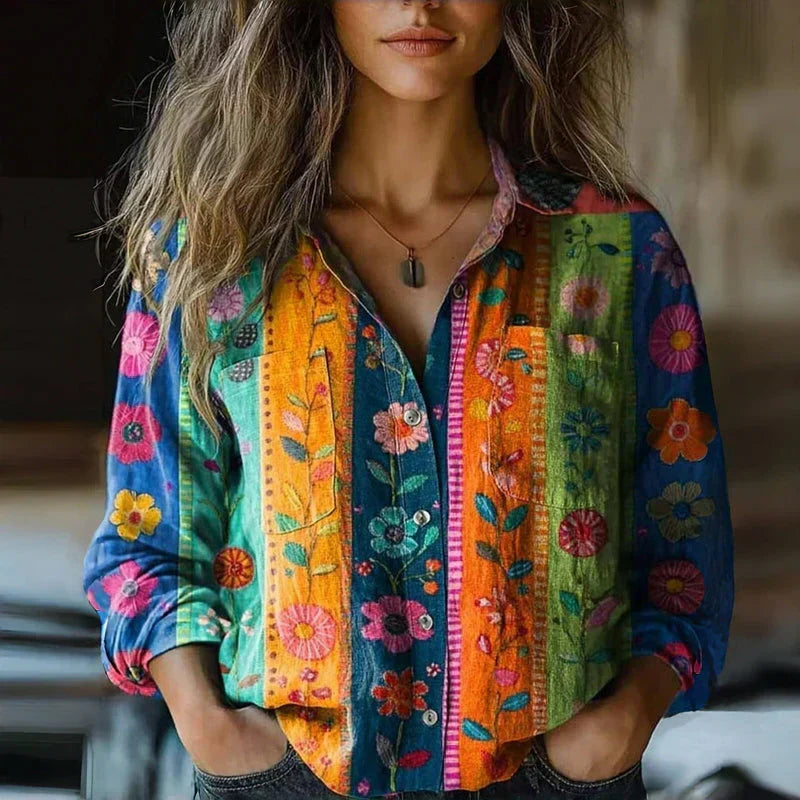 Chemisier vintage multicolore à boutons, col ouvert, motifs fleuris, manches longues retroussées.