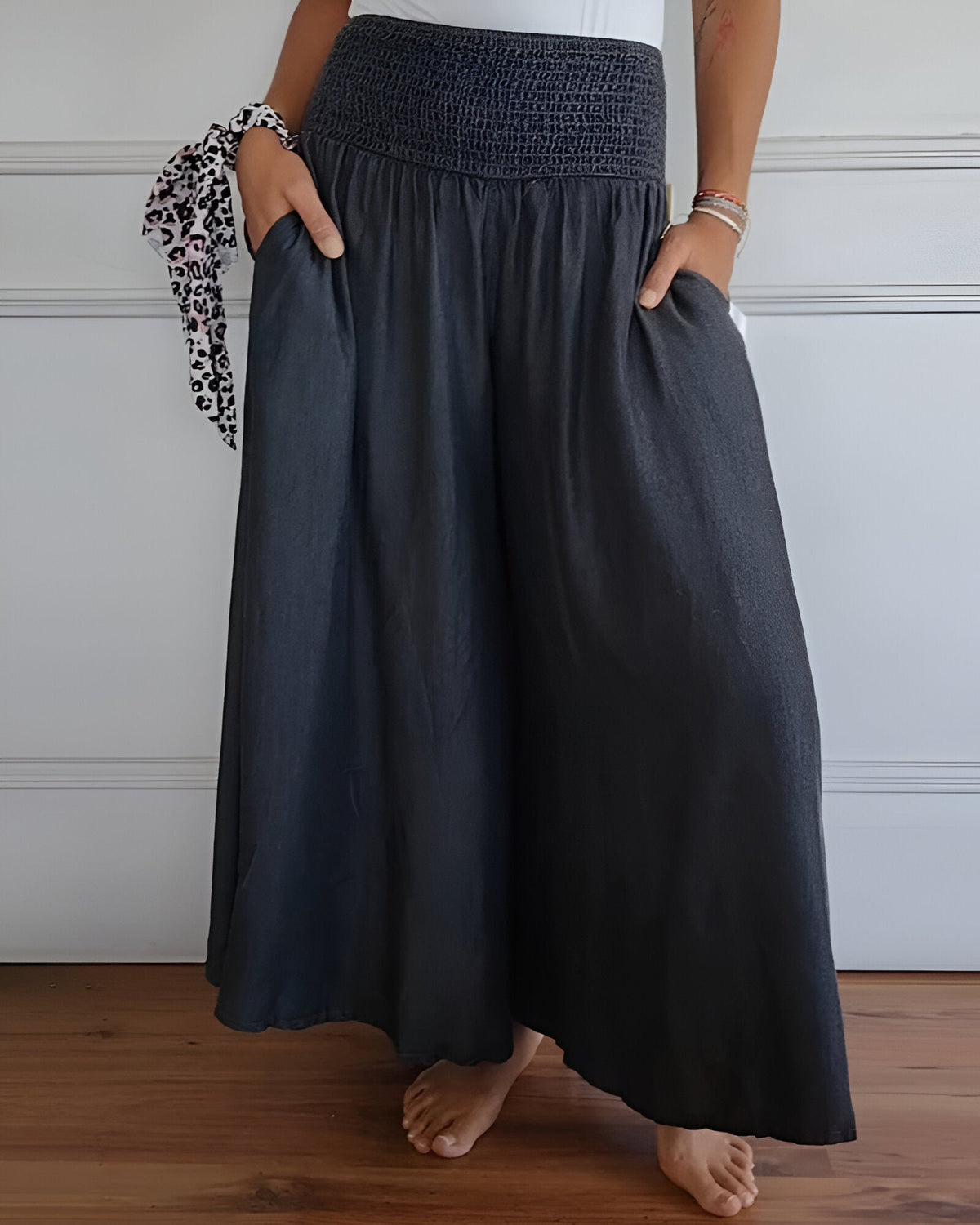Pantalon fluide gris foncé à taille élastique froncée, volume ample sur tout le bas.