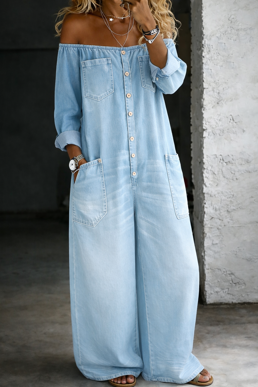 Combinaison en jean bleu clair à épaules dénudées, manches longues boutonnées, poches