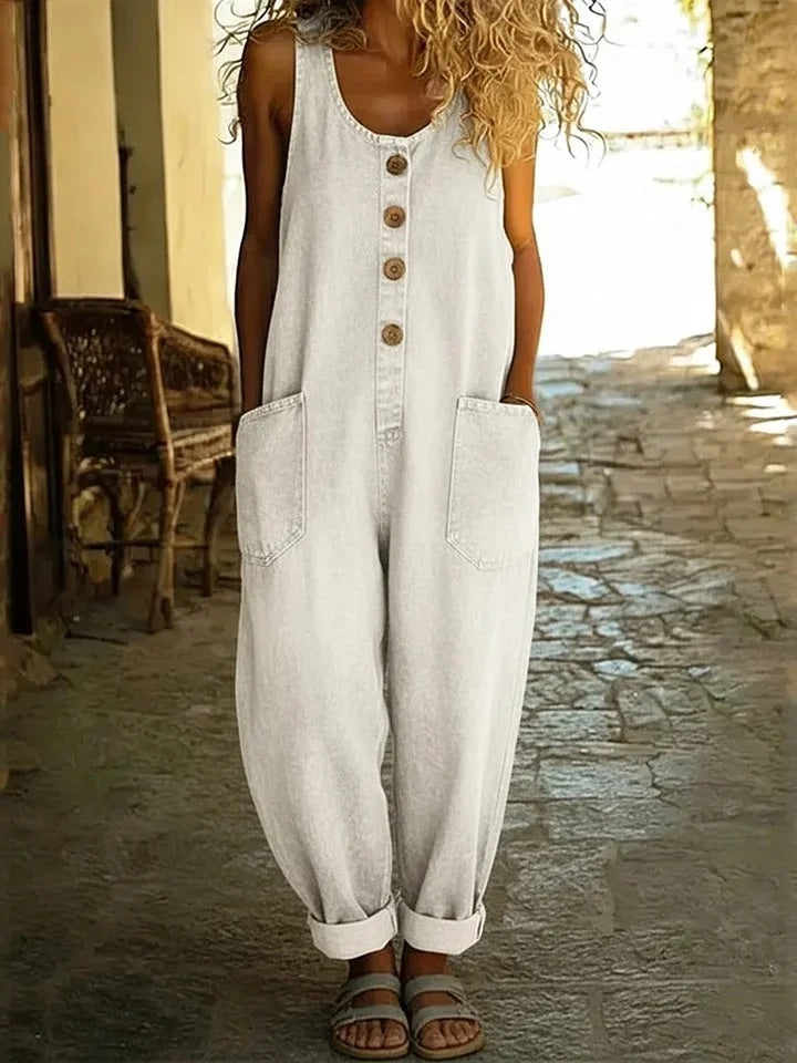 Combinaison en jean blanc cassé sans manches, patte boutonnée, poches latérales, jambes larges.