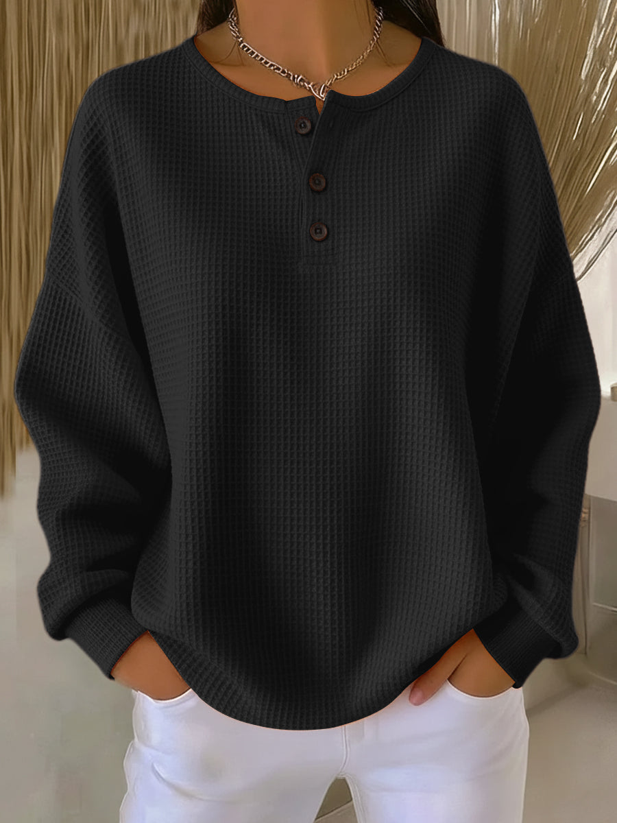 Haut manches longues noir en maille texturée, col henley boutonné à trois boutons.
