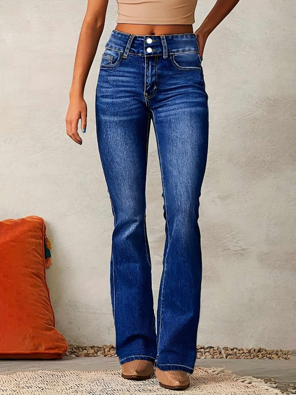 Jean évasé en denim bleu, taille mi-haute, poches et surpiqûres, jambes évasées.
