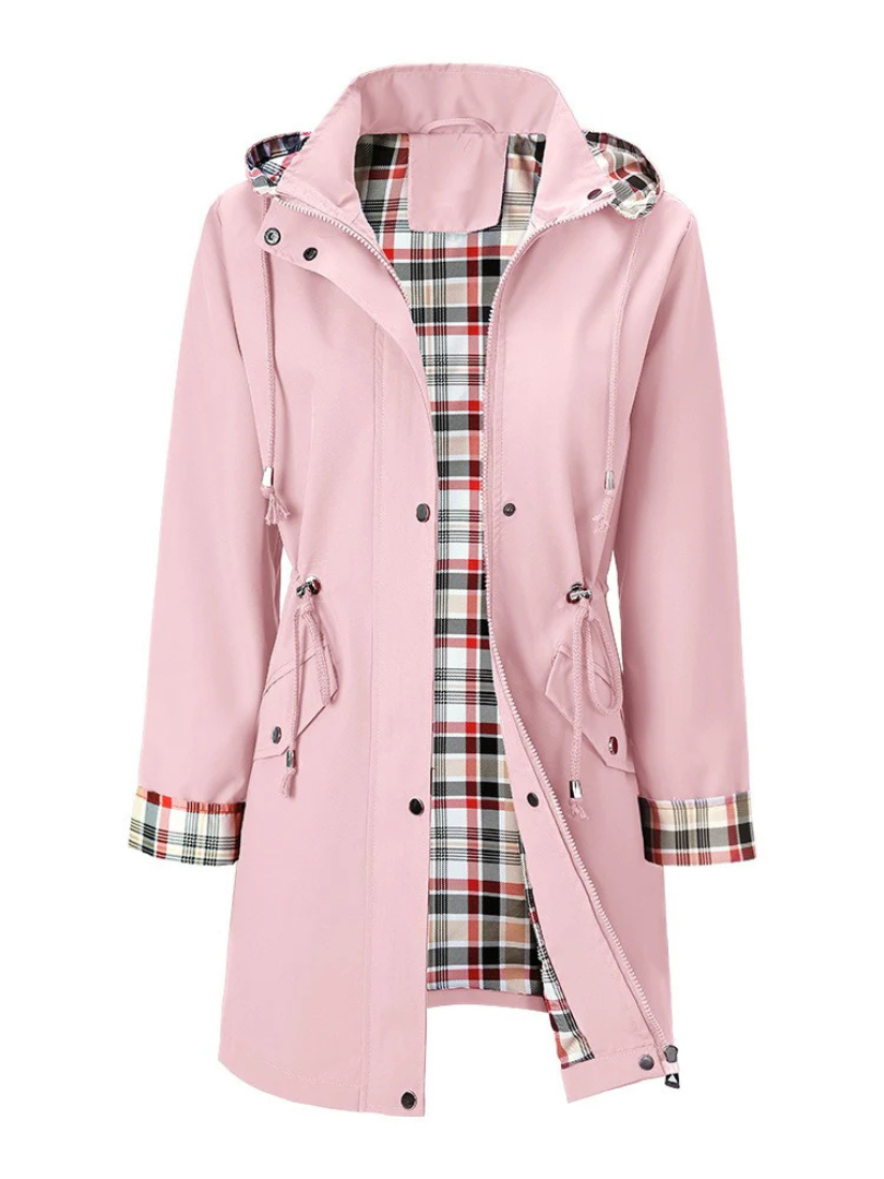 Veste imperméable rose pâle à capuche, fermeture boutonnée, poches et doublure à carreaux.