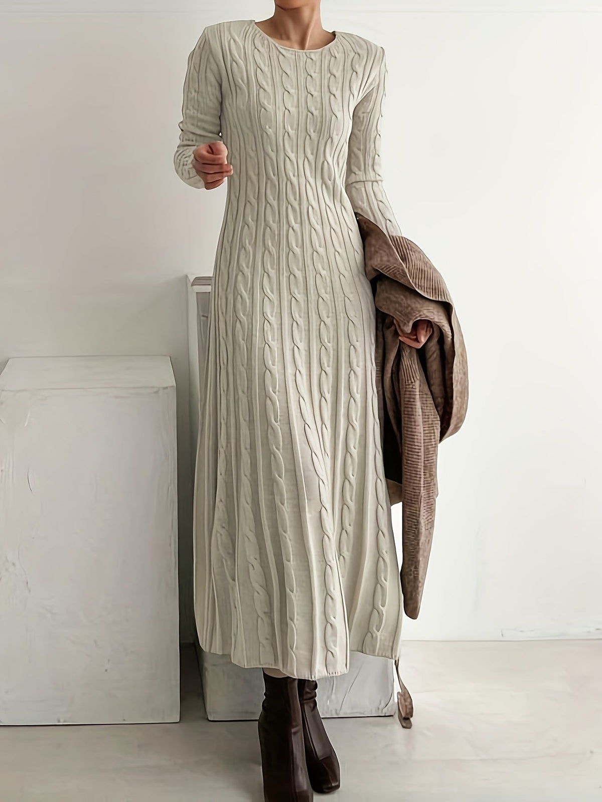 Robe en maille beige à torsades, manches longues, col rond, coupe mi-longue.