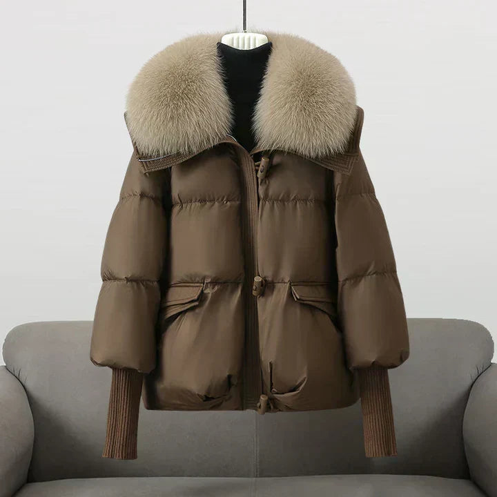Manteau matelassé marron à capuche bordée de fourrure, zip et poches à rabat.