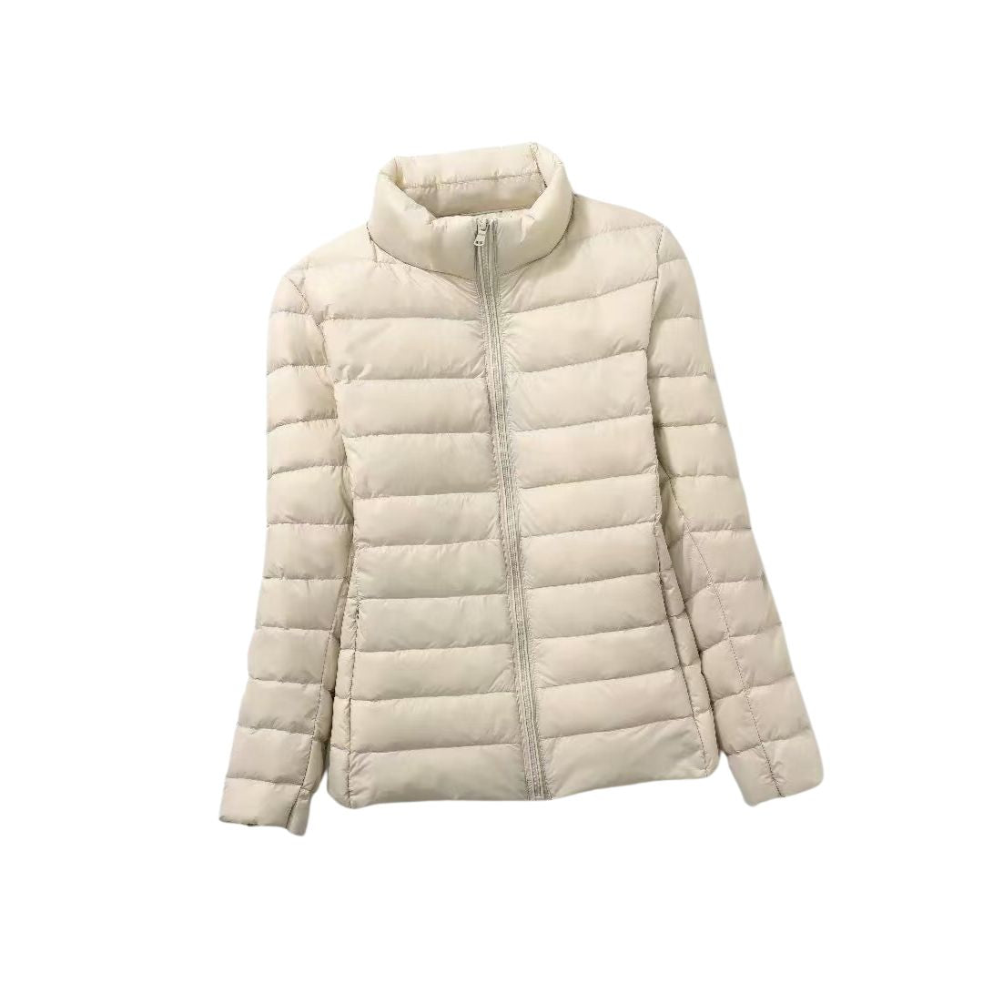 Doudoune ultra-légère beige clair à zip, col montant et matelassage horizontal.