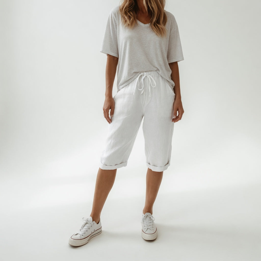 Bermuda en coton blanc avec taille élastique et cordon, longueur mi-mollet.