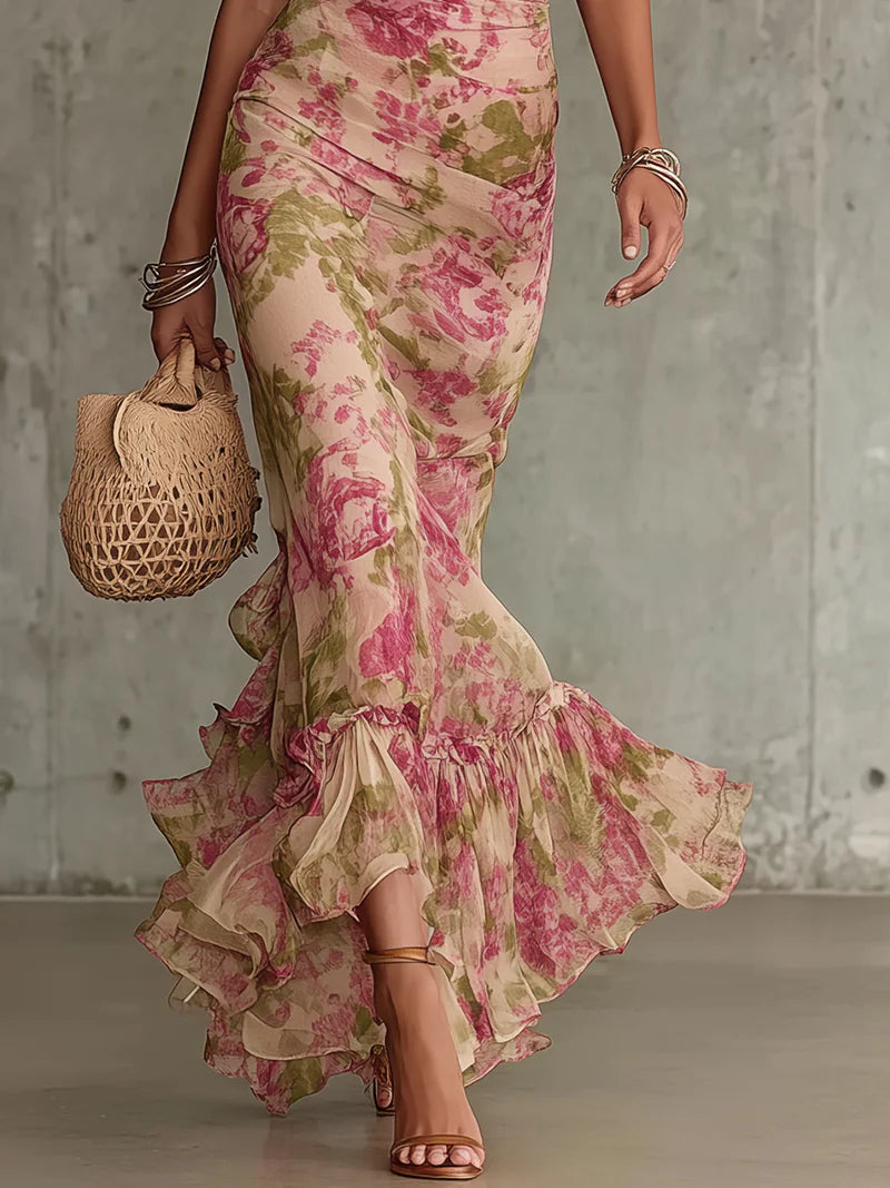 Robe longue rose imprimée de fleurs, taille cintrée, manches bouffantes et bas à volants.