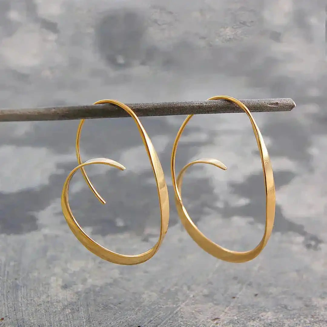 Boucles d’oreilles pendantes spirales ouvertes dorées, grands anneaux ovales.