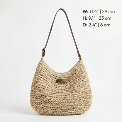 Sac en paille beige en forme demi-lune avec anse marron et patch rectangulaire.