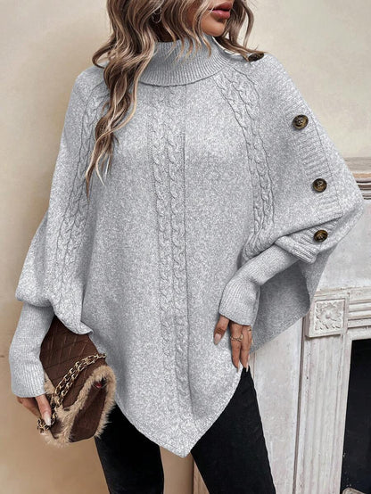 Poncho en maille torsadée beige clair, col montant, ourlet asymétrique, boutons décoratifs