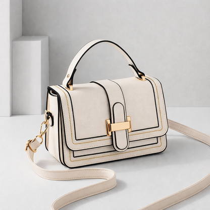 Sac à main en cuir crème avec rabat et fermoir doré, bandoulière réglable.