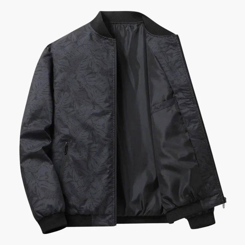 Blouson bomber gris foncé à imprimé feuilles, fermeture zippée, col montant et poignets côtelés.