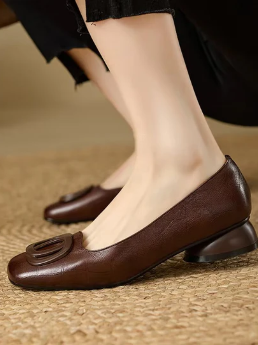 Ballerines en cuir marron à bout carré, décor circulaire, portées avec jean.