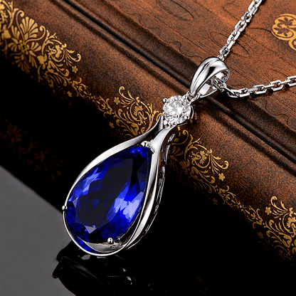 Pendentif argenté en forme d’infini avec saphir bleu goutte et pierre claire