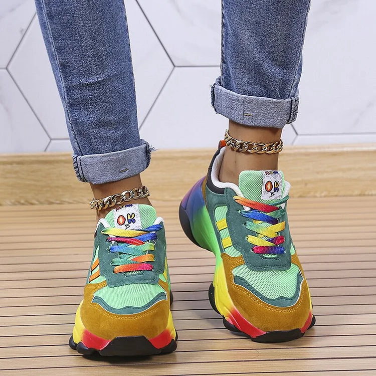 Baskets vertes à lacets multicolores, semelle arc-en-ciel, chaînette et jean retroussé