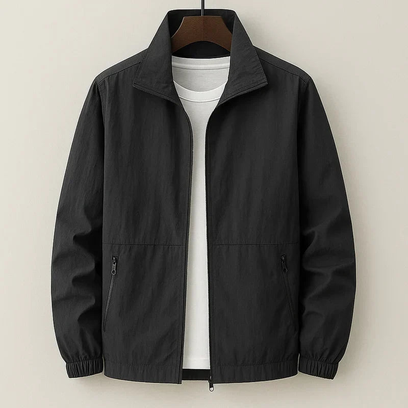 Blouson bomber léger noir, zip central, col chemise, poignets élastiques, poches zippées.