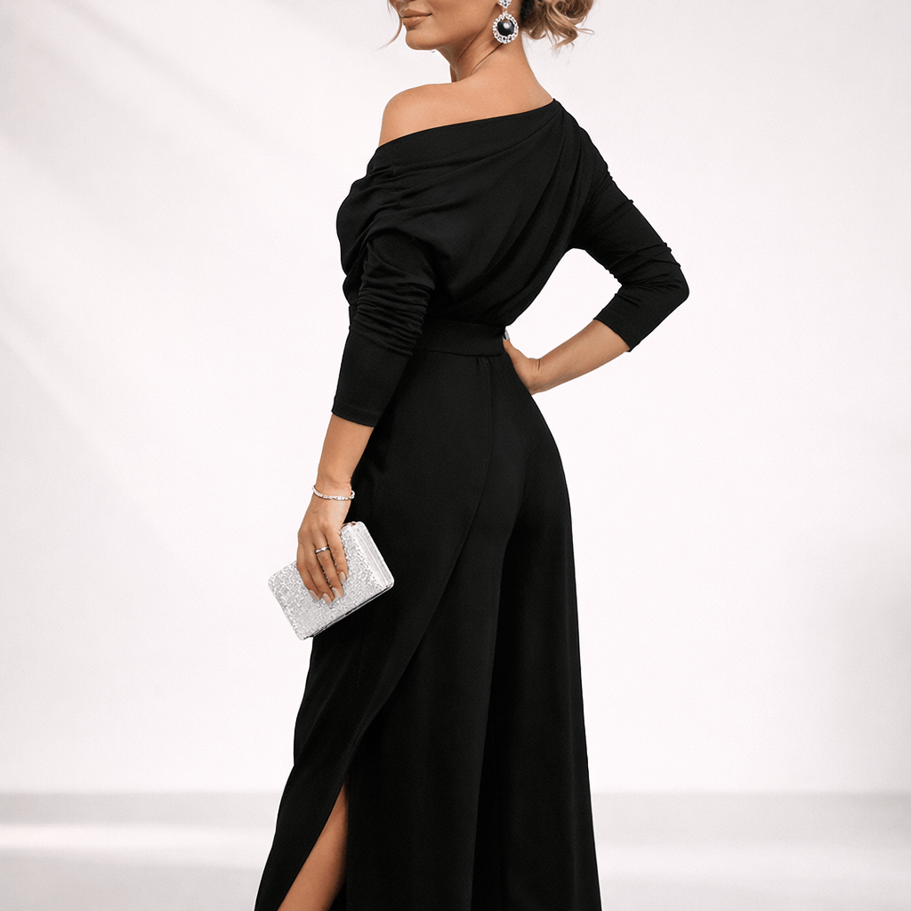 Combinaison noire à épaules asymétriques, manches longues, ceinture à la taille, jambes larges fendu.