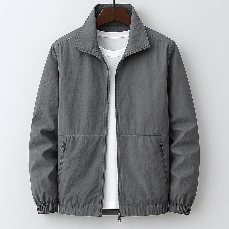 Blouson bomber léger gris, zip central, col chemise, poignets élastiques, poches zippées.