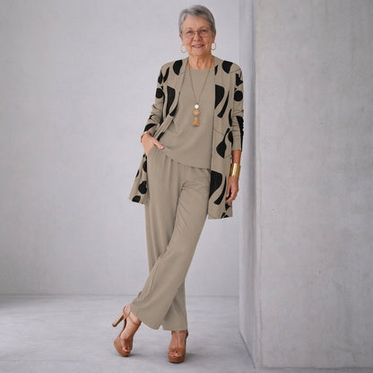 Ensemble 3 pièces : veste longue à motifs noirs, haut et pantalon beige assortis.