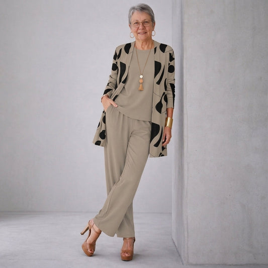 Ensemble 3 pièces : veste longue à motifs noirs, haut et pantalon beige assortis.