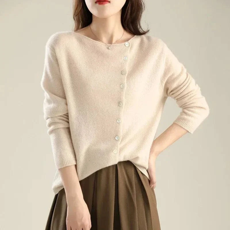 Gilet en tricot beige clair à boutons, encolure ronde et manches longues.