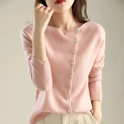 Gilet en tricot rose poudré à boutons, encolure ronde et manches longues.
