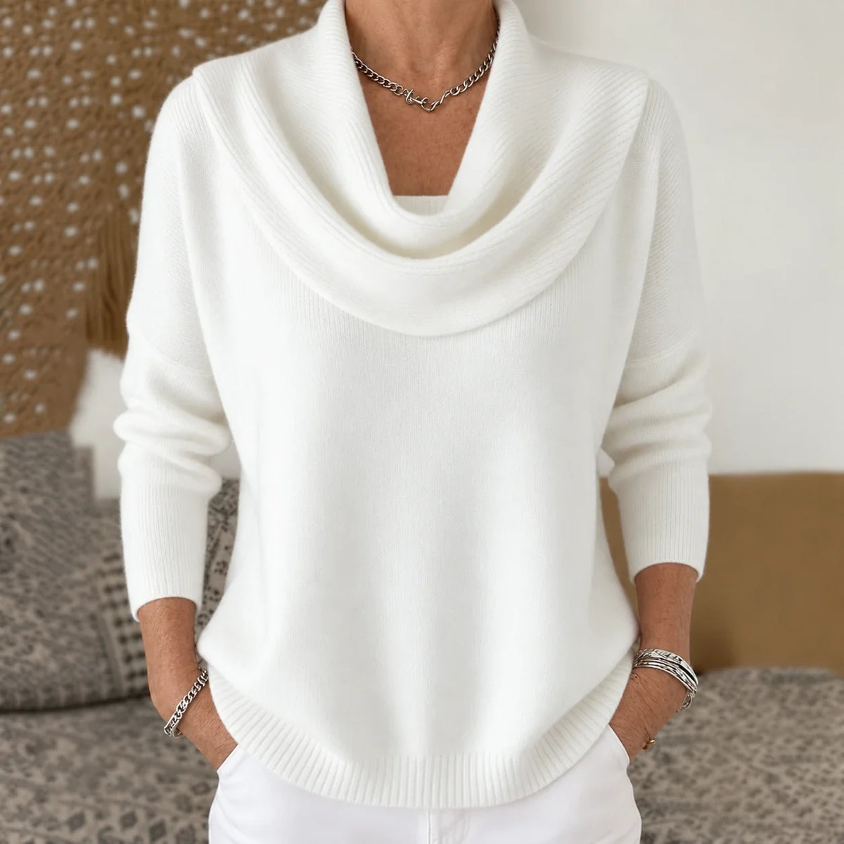 Pull à col drapé en maille blanche, encolure tombante et manches longues.
