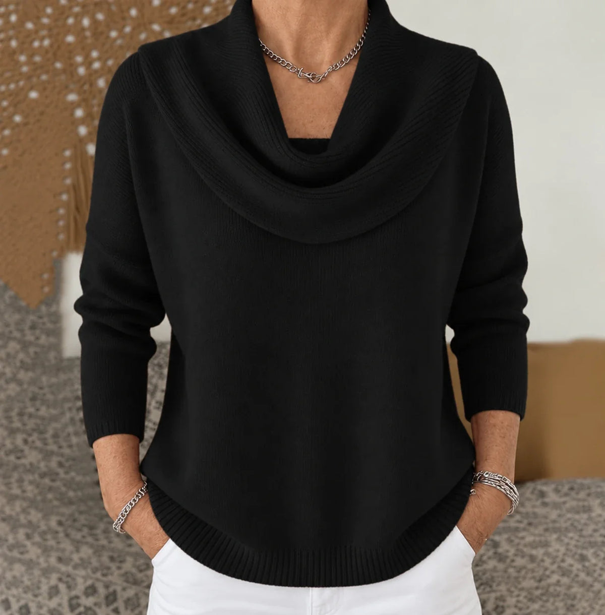 Pull à col drapé en maille noire, encolure tombante et manches longues.