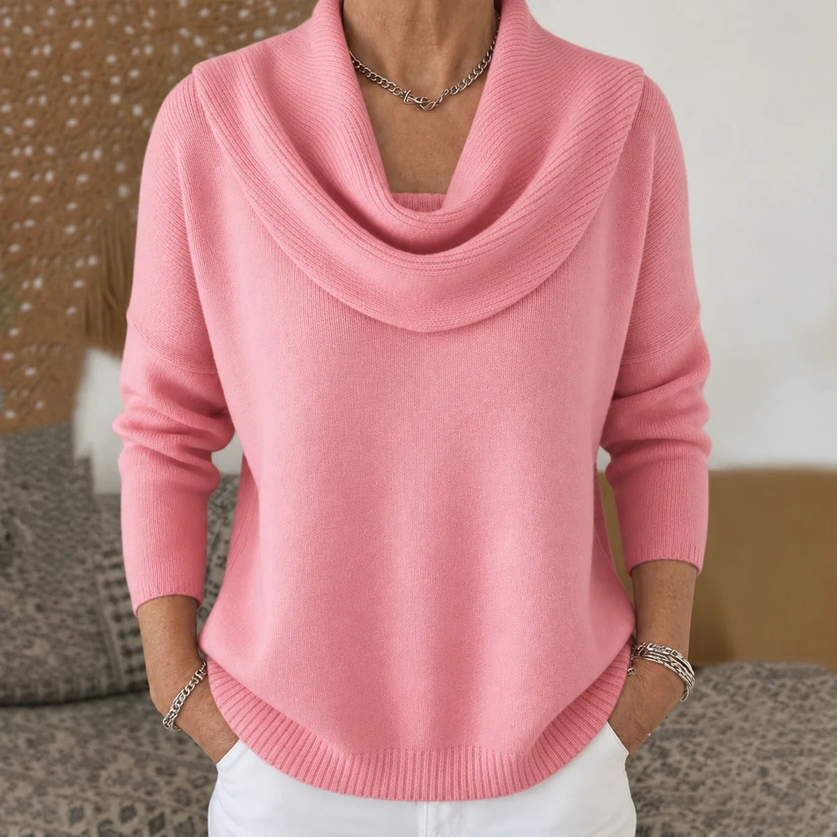 Pull à col drapé en maille rose, encolure tombante et manches longues.