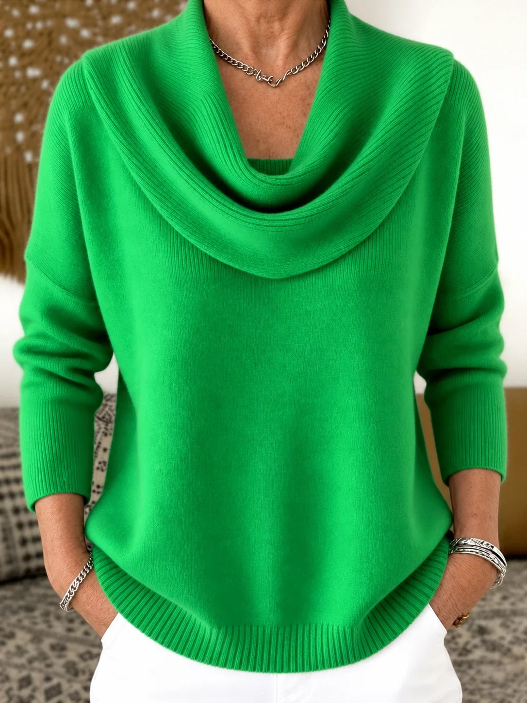 Pull à col drapé en maille vert vif, encolure tombante et manches longues.