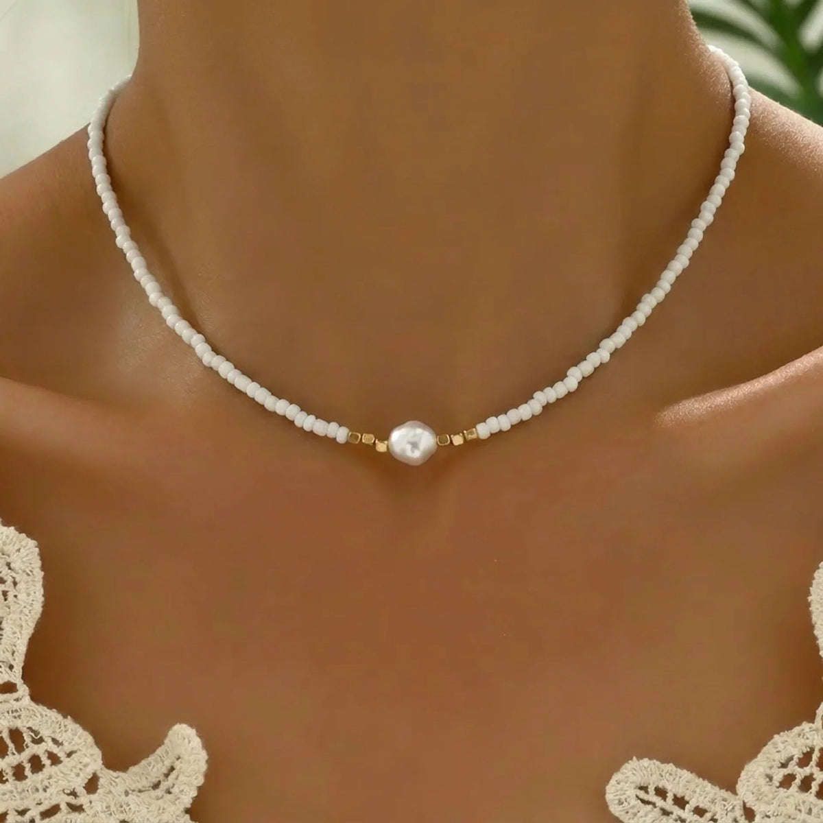 Collier minimaliste à perles blanches et perle nacrée centrale, intercalaires dorés