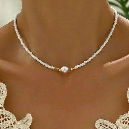 Collier minimaliste à perles blanches et perle nacrée centrale, intercalaires dorés
