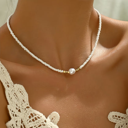 Collier minimaliste à perles blanches avec perle nacrée centrale et intercalaires dorés