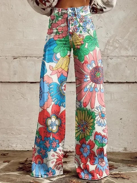 Pantalon ample blanc cassé à fleurs colorées, jambes évasées, taille boutonnée.