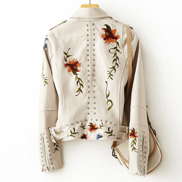 Veste en cuir blanc à broderies florales, boutons pression et clous décoratifs.