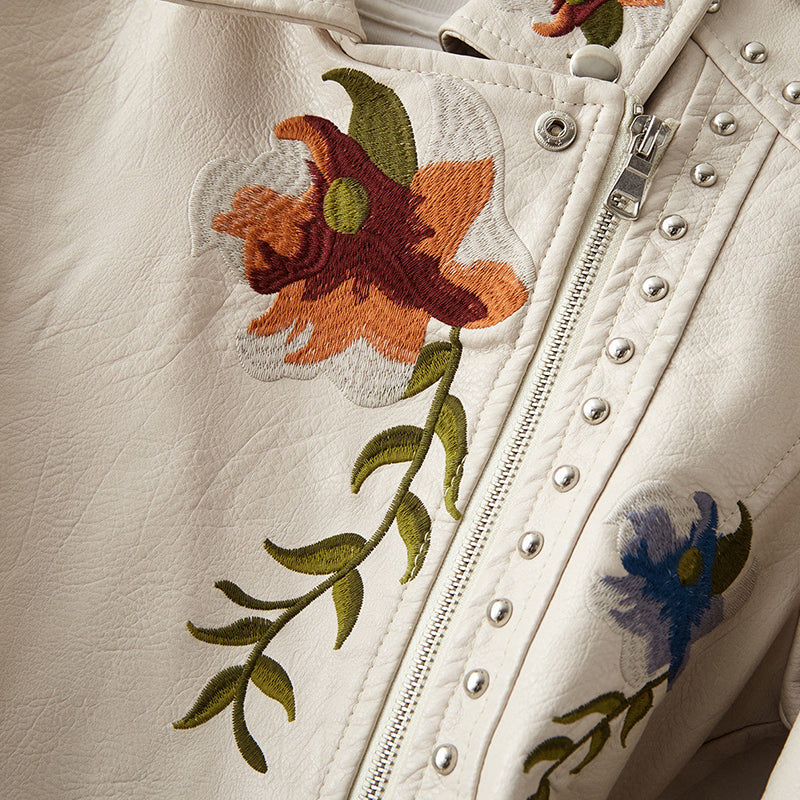 Veste en cuir blanc, détail broderies fleuries et rangée de boutons devant.