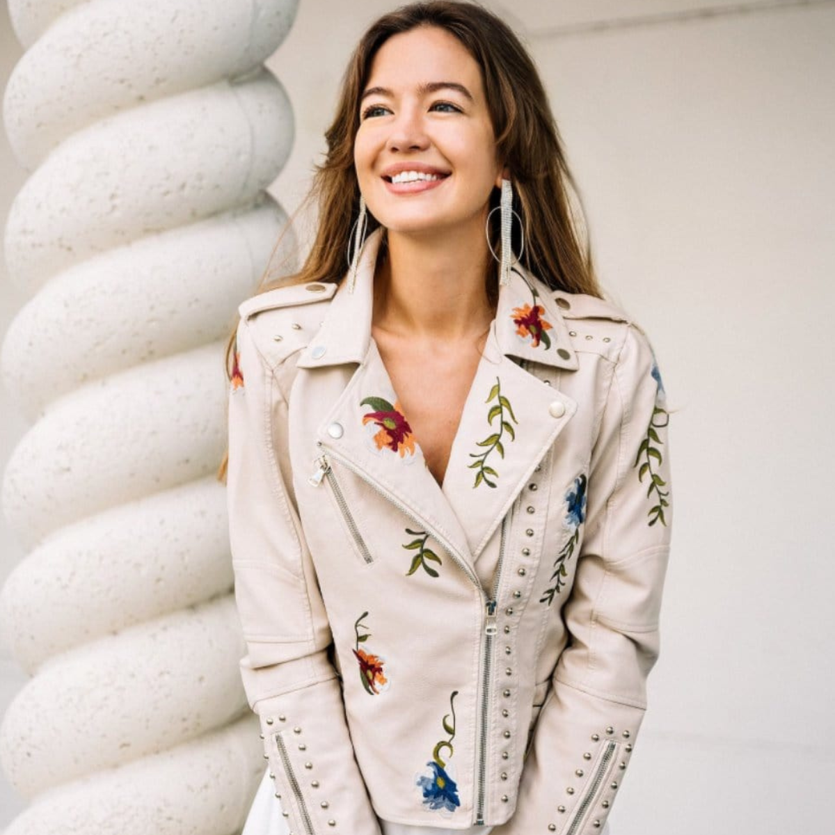Veste en cuir blanc brodée, col avec zip et coutures cloutées, vue de face.