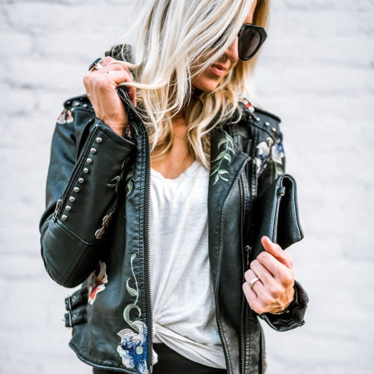 Veste en cuir noire fleurie avec épaulettes, fermeture zippée et poches zippées