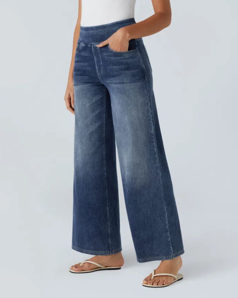 Jean à jambe large en denim bleu, taille mi-haute, poches avant et effet délavé.