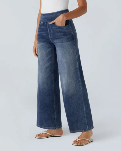 Jean à jambe large en denim bleu, taille mi-haute, poches avant et effet délavé.