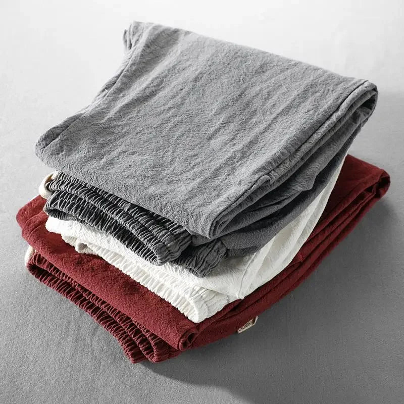 Pantalons décontractés empilés, taille élastique, tons gris et bordeaux.
