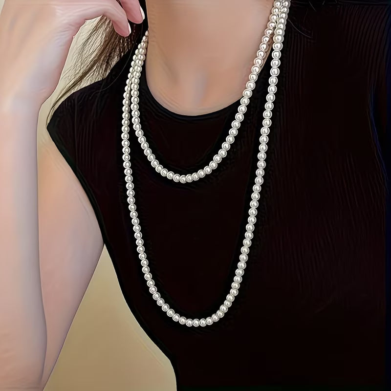 Collier double perles nacrées blanches en deux rangs, porté sur haut noir.
