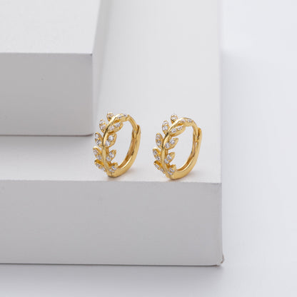 Boucles d’oreilles créoles dorées en forme de feuilles, décor détaillé.
