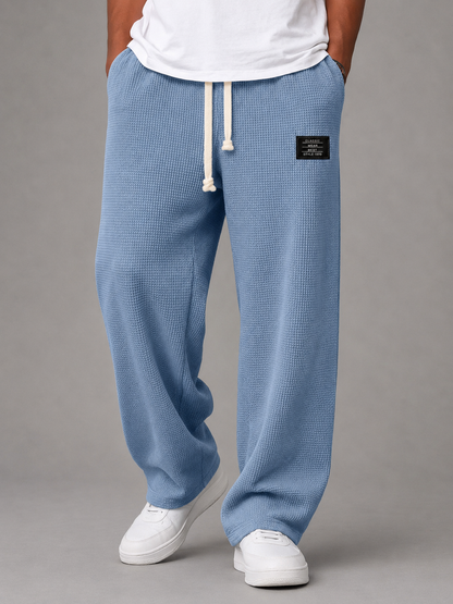 Pantalon ample bleu clair à taille élastique et cordon, étiquette sur la hanche.