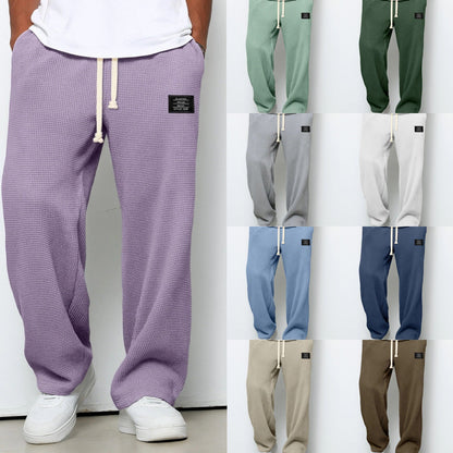 Pantalon ample violet à taille élastique et cordon, étiquette sur la hanche droite.