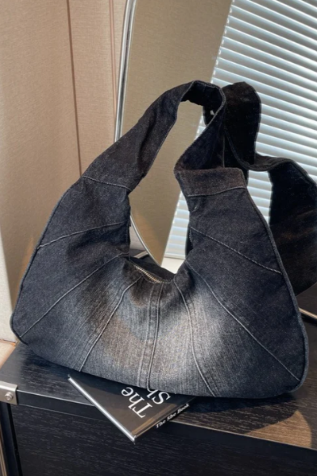 Grand sac hobo en jean gris foncé, anses larges et bandoulière.