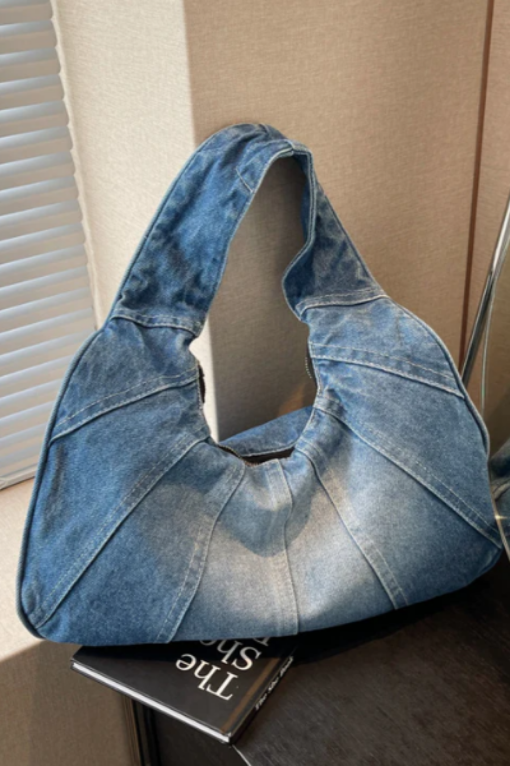 Grand sac hobo en jean bleu, ouverture large sans fermeture visible.